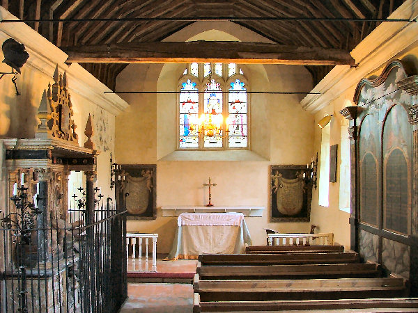 A Hampshire church interior: the chancel, with a monument, hatchments and box pews